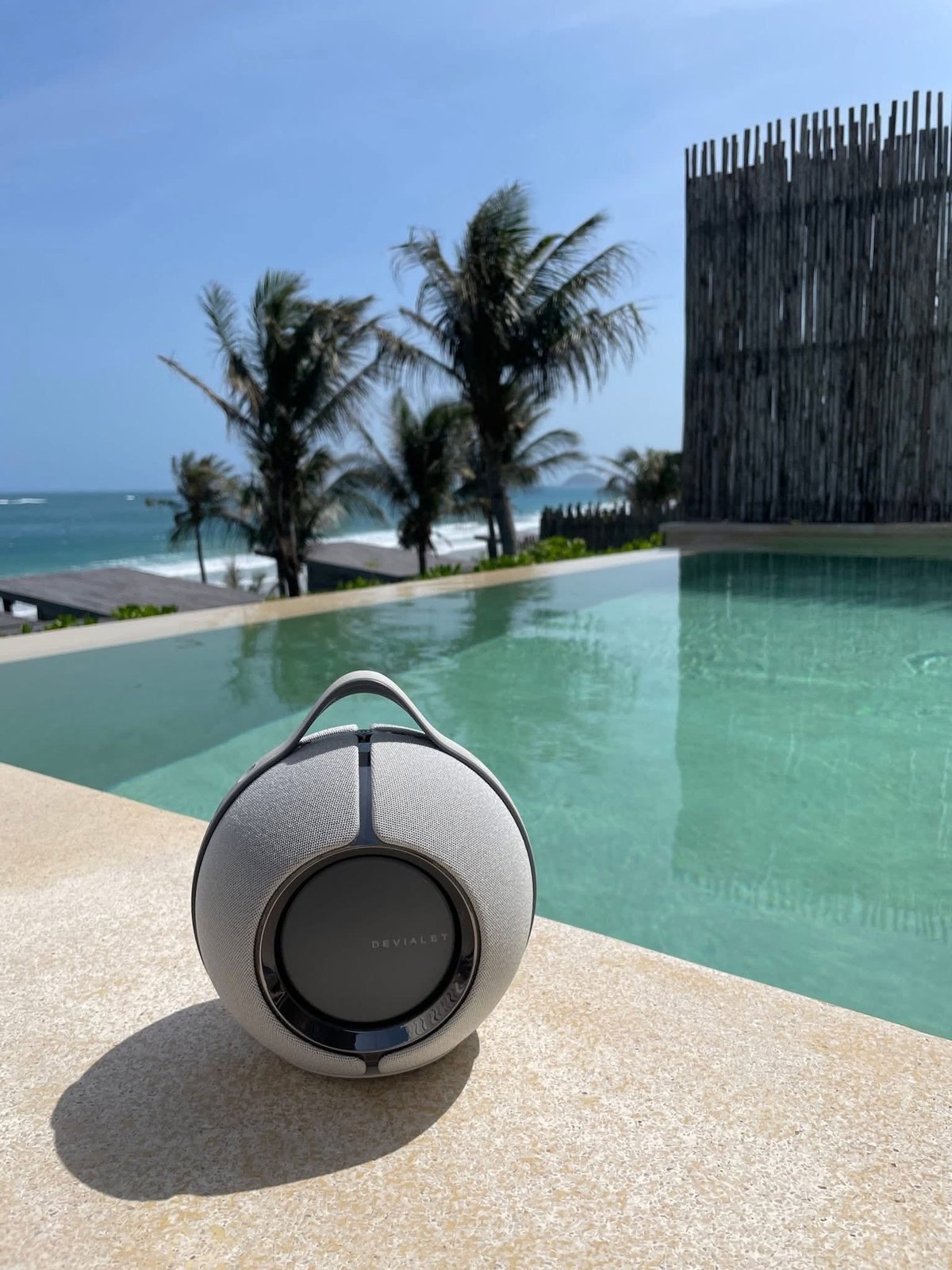 Devialet Mania màu xám đặt cạnh bể bơi vô cực