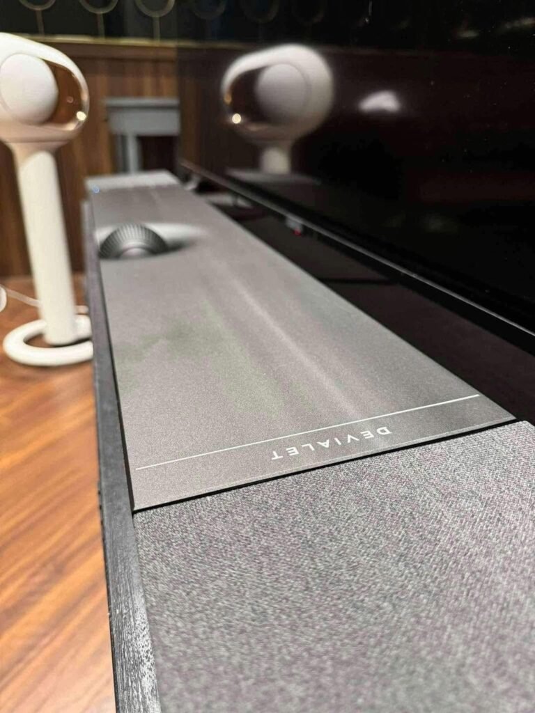 Cận cảnh bề mặt vải và logo trên soundbar Devialet Dione